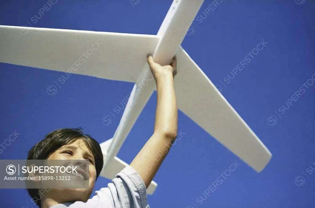 Low angle view of boy with glider plane