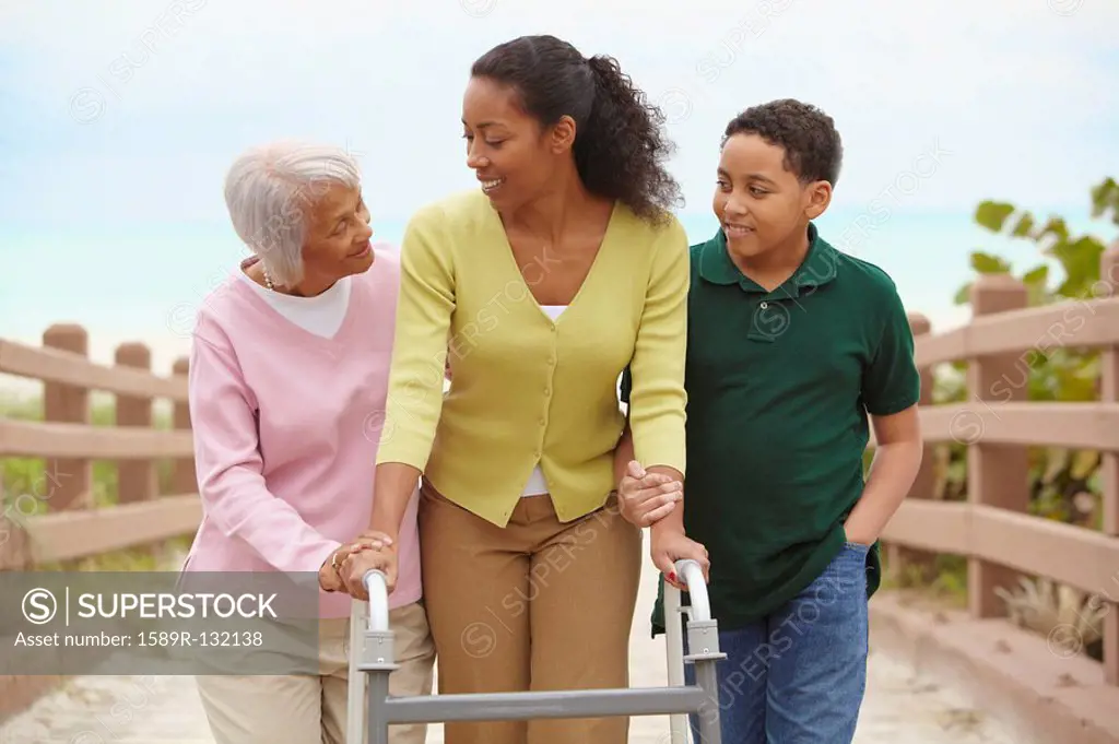 African American woman using walker with help of family