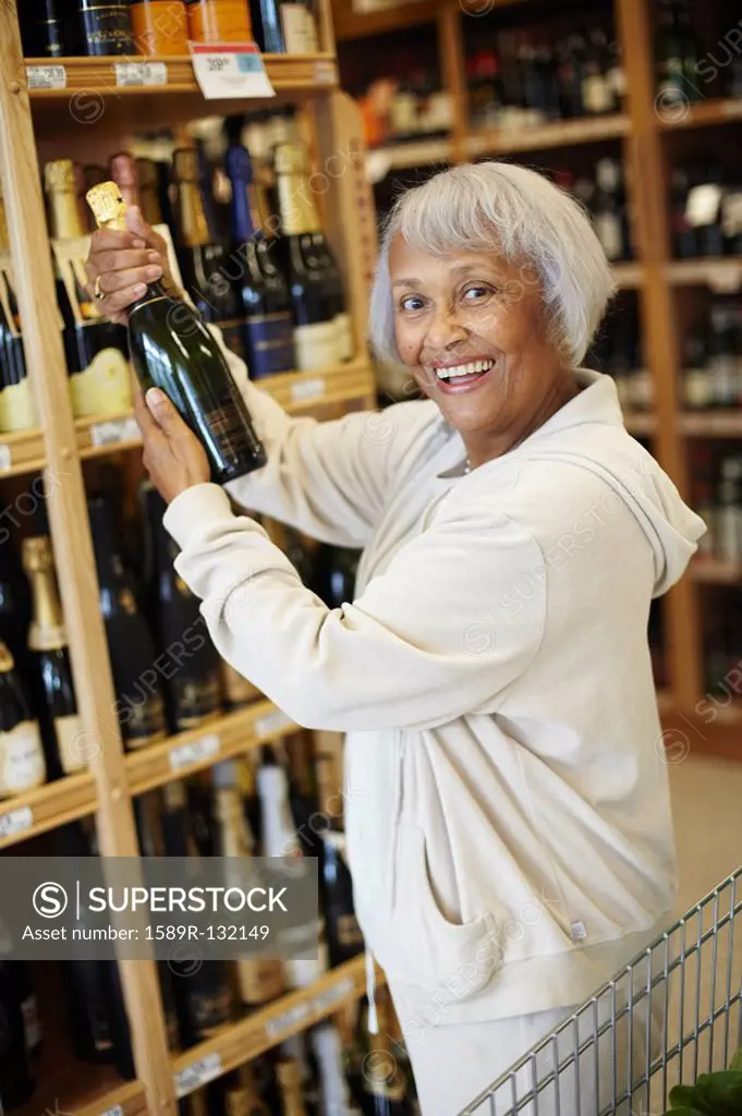 Senior African American woman buying champagne