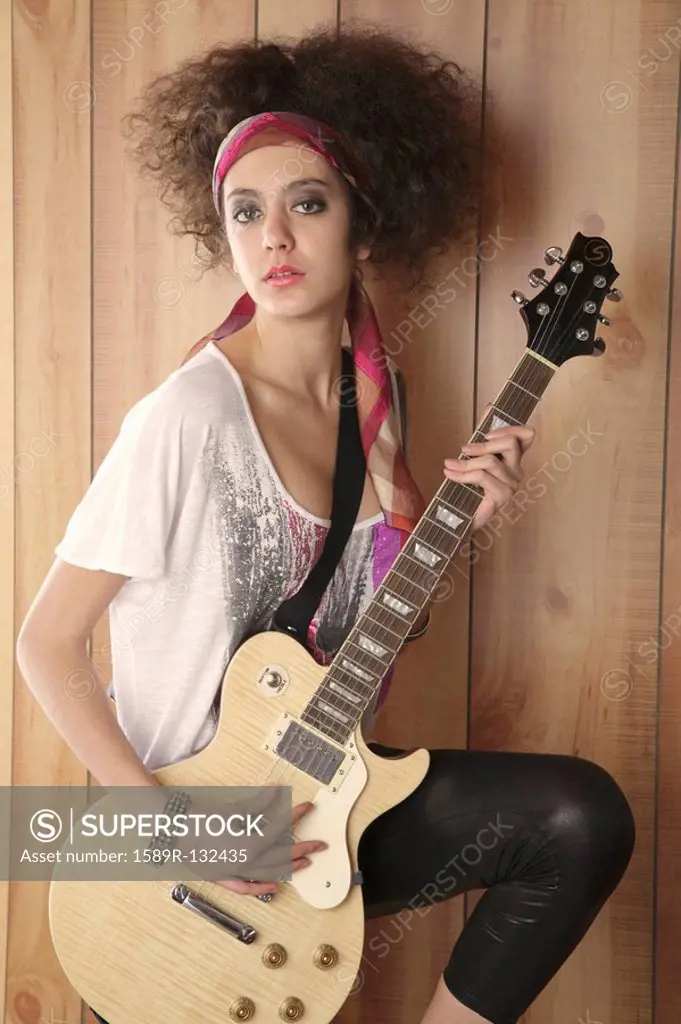 Hispanic girl playing electric guitar
