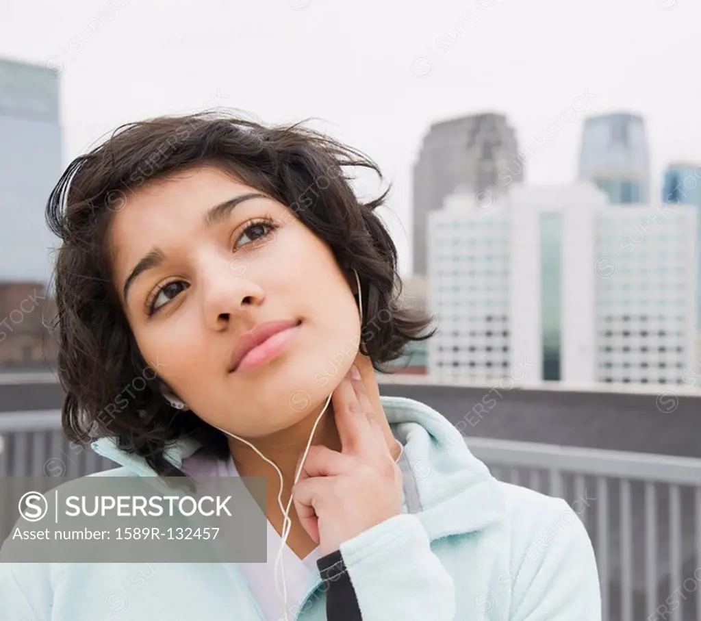 Hispanic woman checking pulse in city