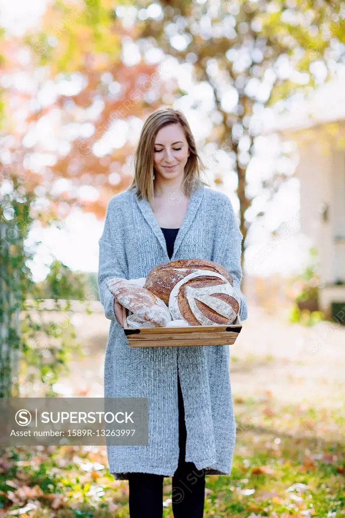 Caucasian woman holding bread outdoors