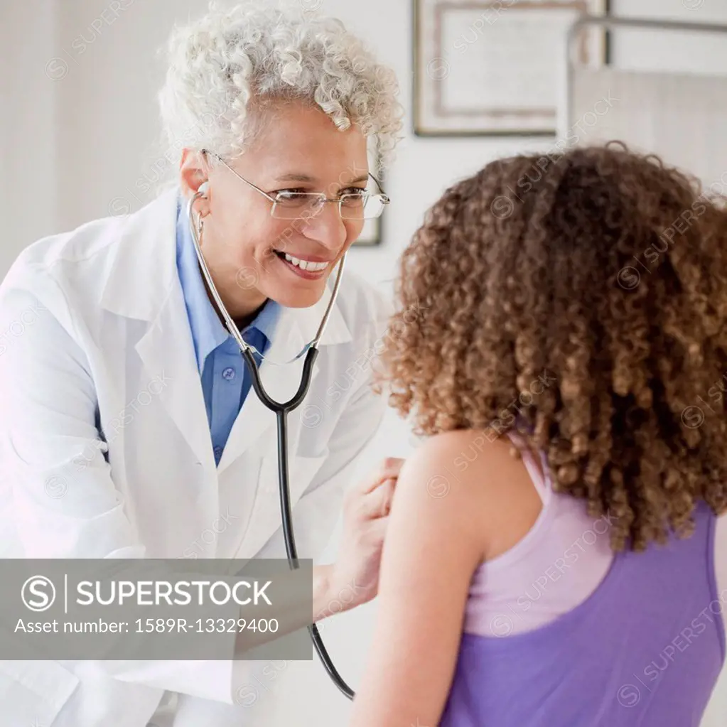 Doctor checking girl's heart with stethoscope
