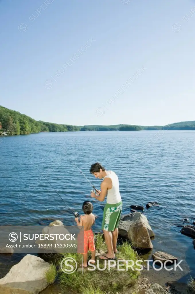 Mixed race father and son fishing in lake