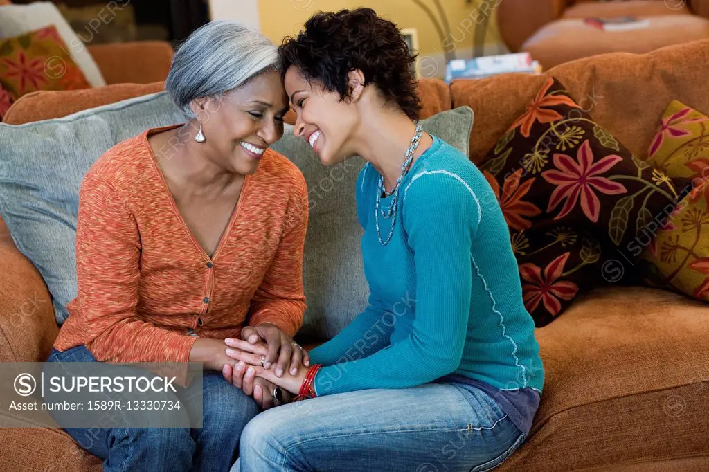 African American mother talking with daughter in living room