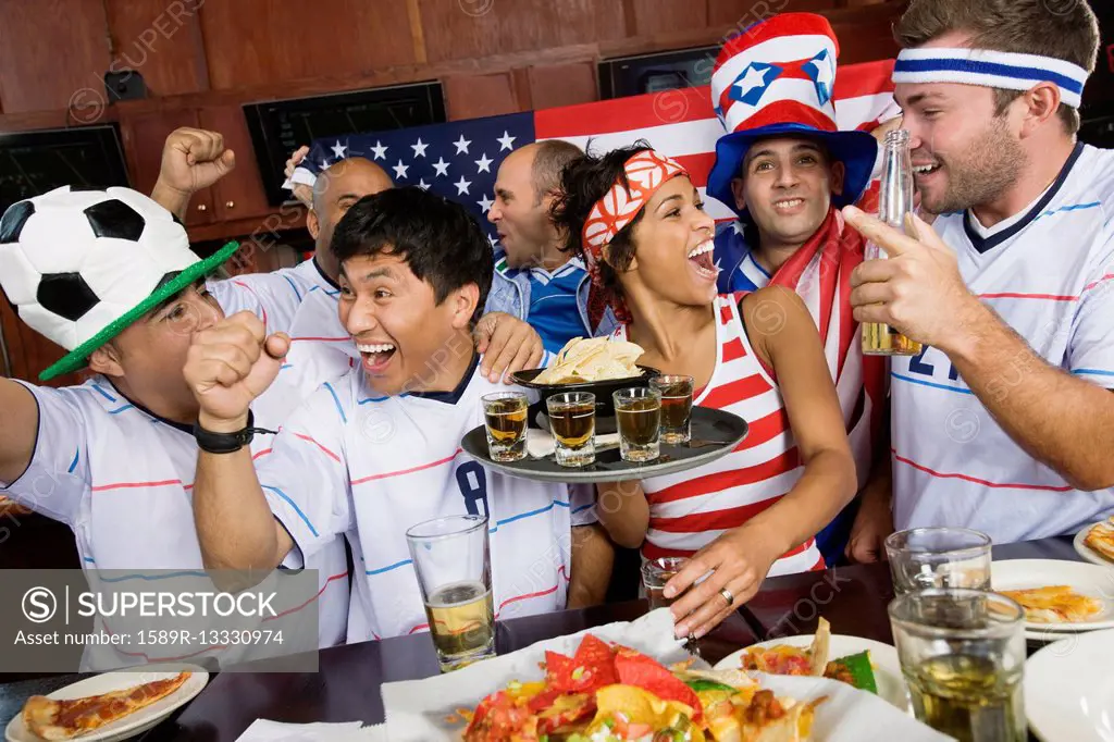 Sports fans drinking and eating in sports bar
