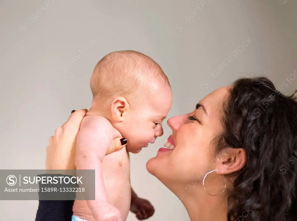 Mother holding newborn baby face to face