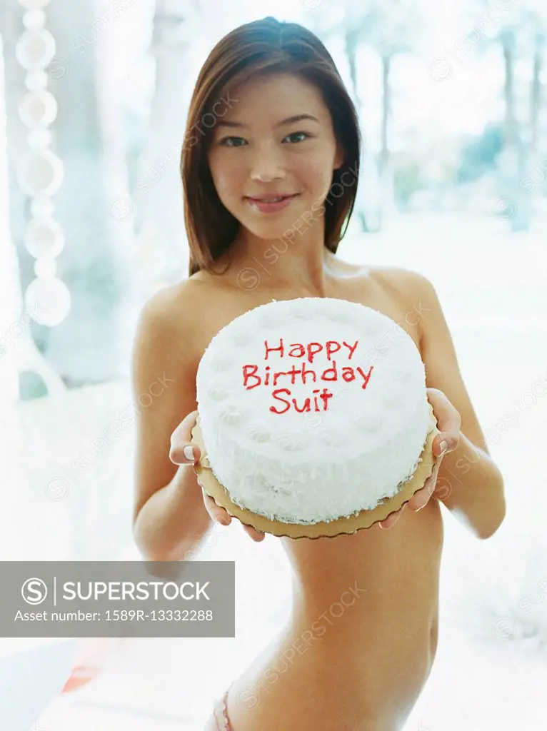 Naked woman holding birthday cake