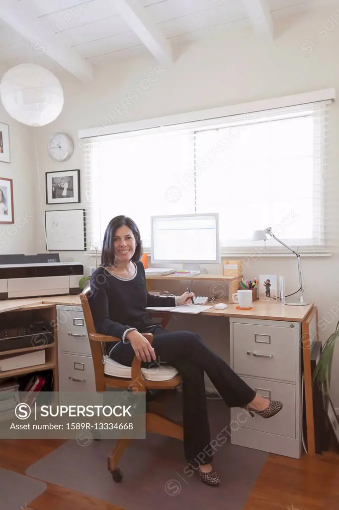 Hispanic woman working in home office