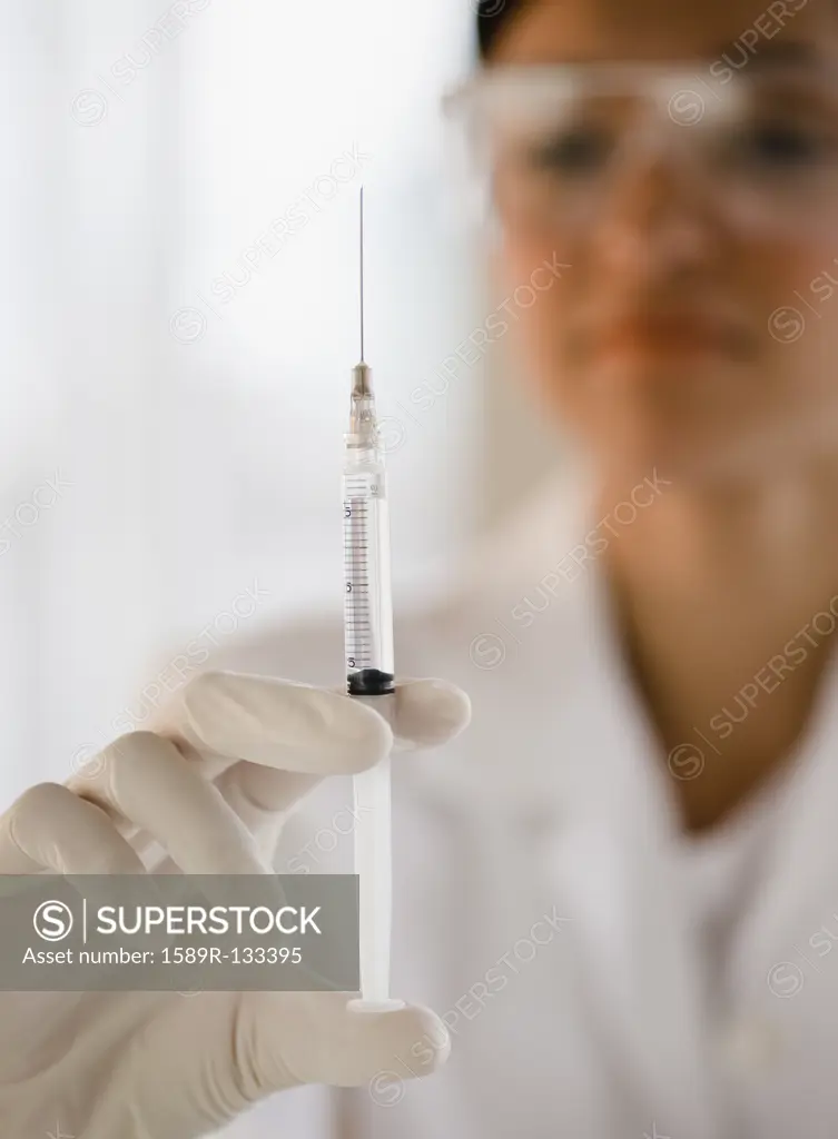 Mixed race doctor holding syringe