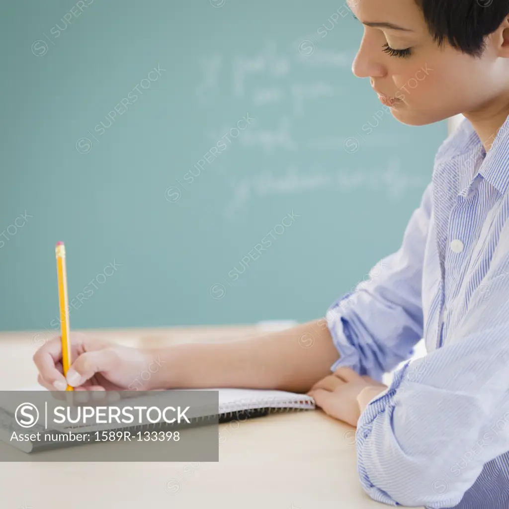 Mixed race woman writing in notebook