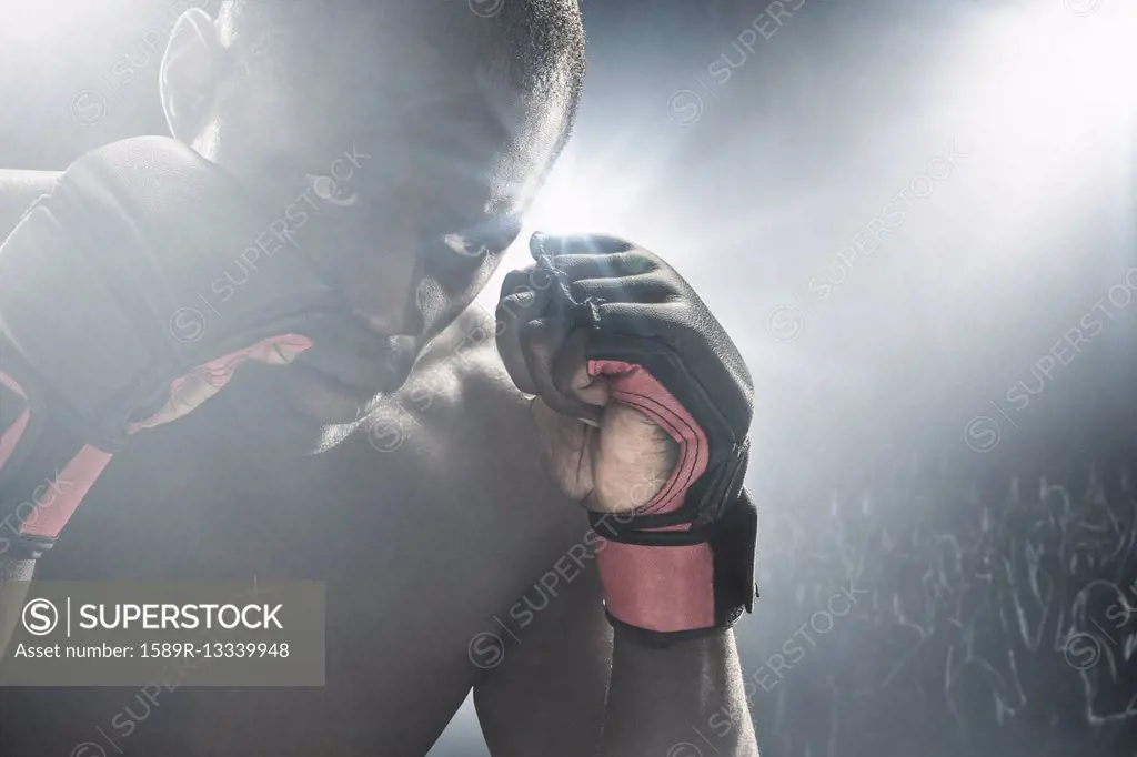 African American MMA boxer with gloves raised