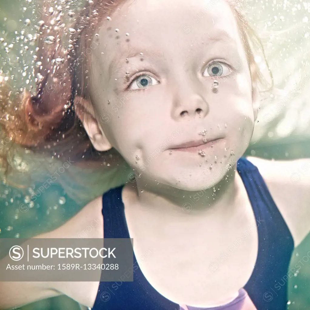 Caucasian girl swimming under water