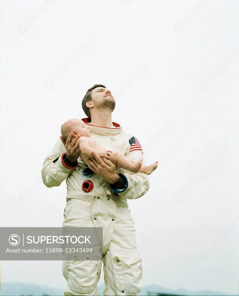 Astronaut holding baby outdoors