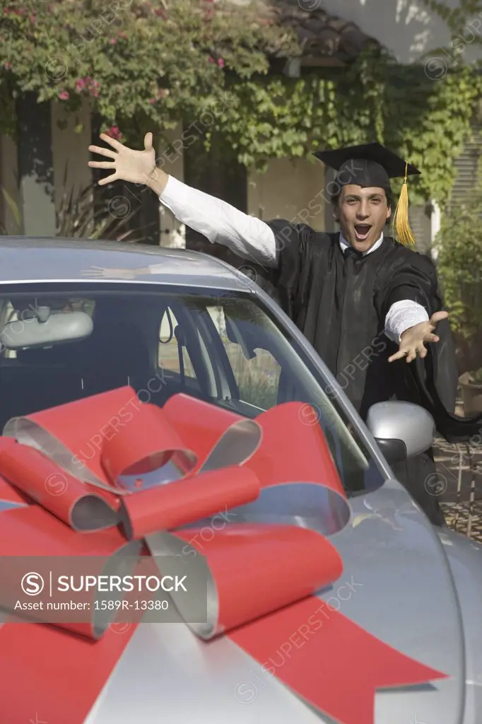 Portrait of graduating man with new car