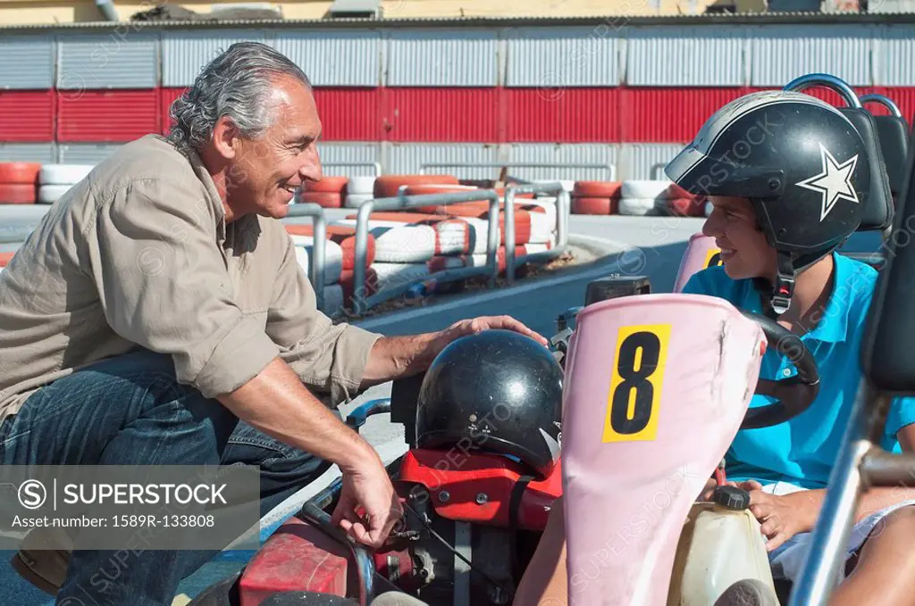 Hispanic grandfather and grandson on go_cart track