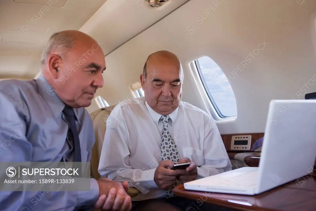 Hispanic businessmen working on private jet