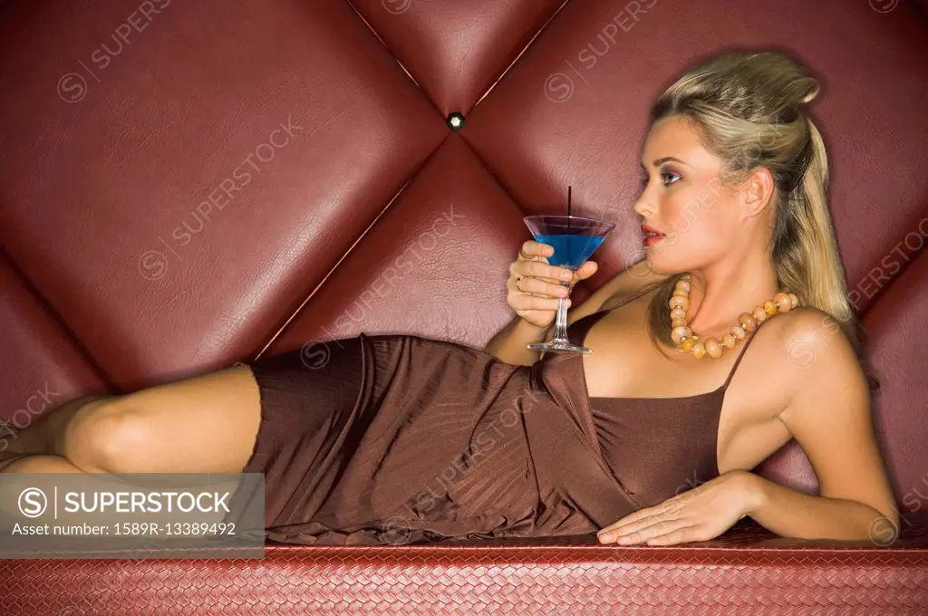 Woman in evening dress drinking cocktail