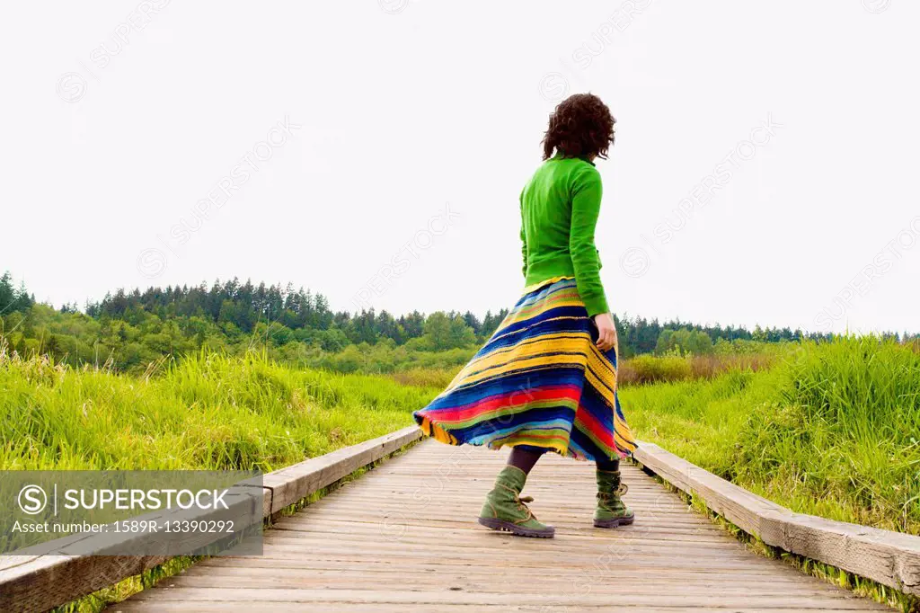 Asian woman walking on wooden path