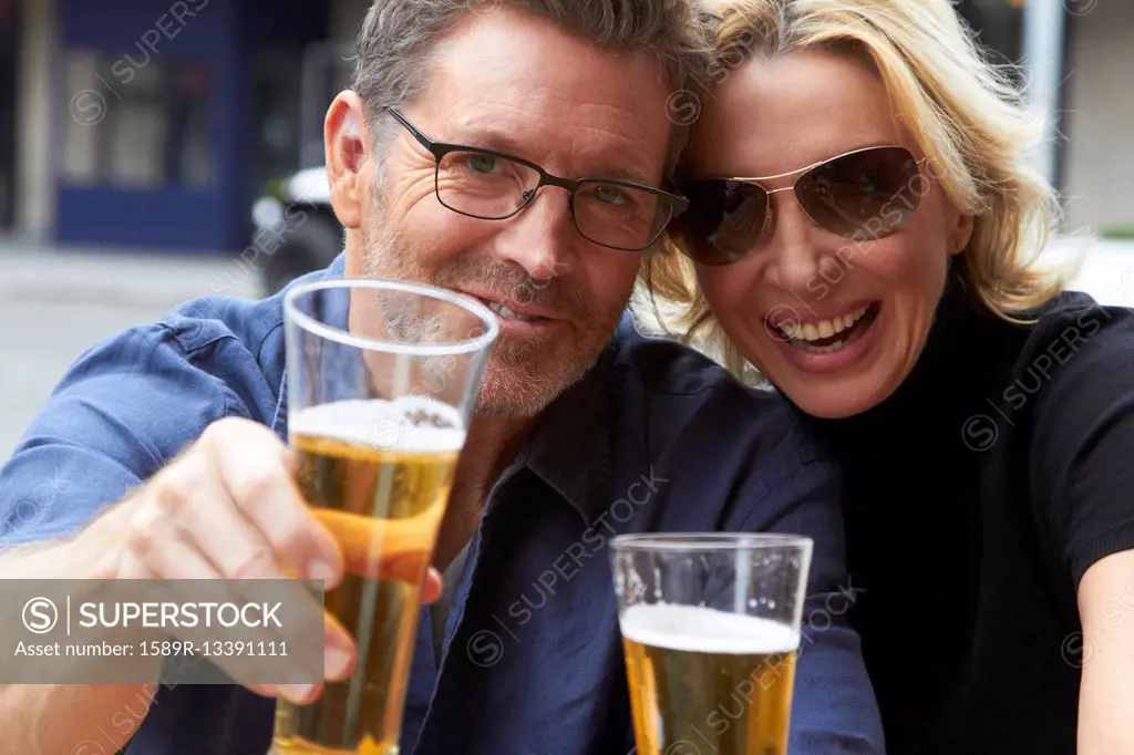Caucasian couple drinking beer outdoors
