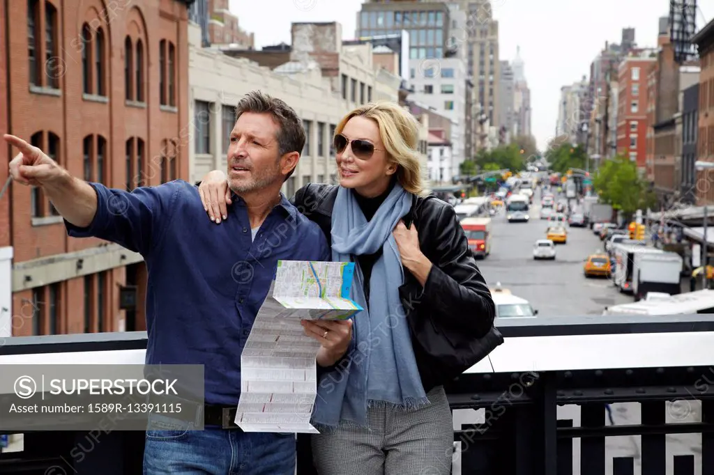 Caucasian couple holding map in city, New York City, New York, United States