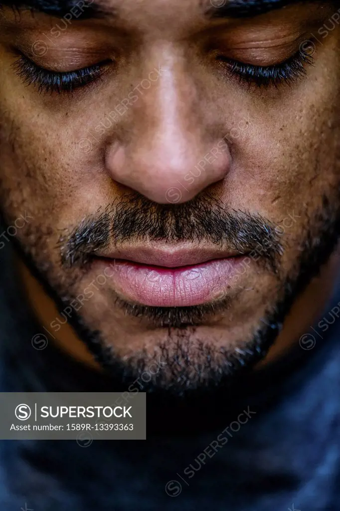 Close up of face mixed race man looking down