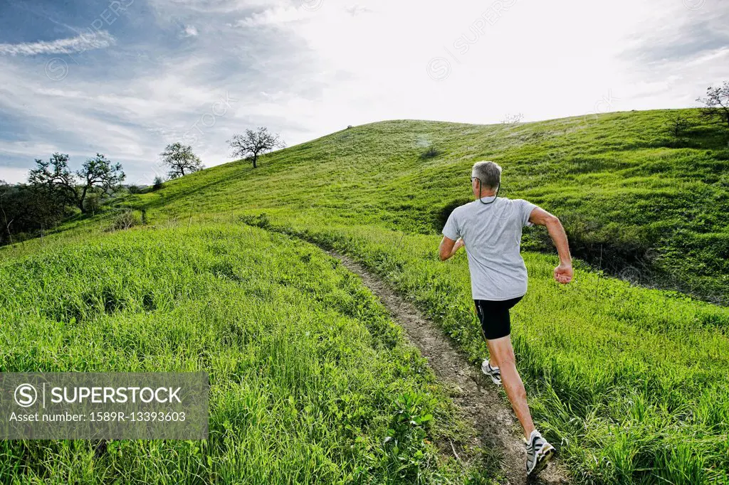 Older Caucasian man jogging on dirt path