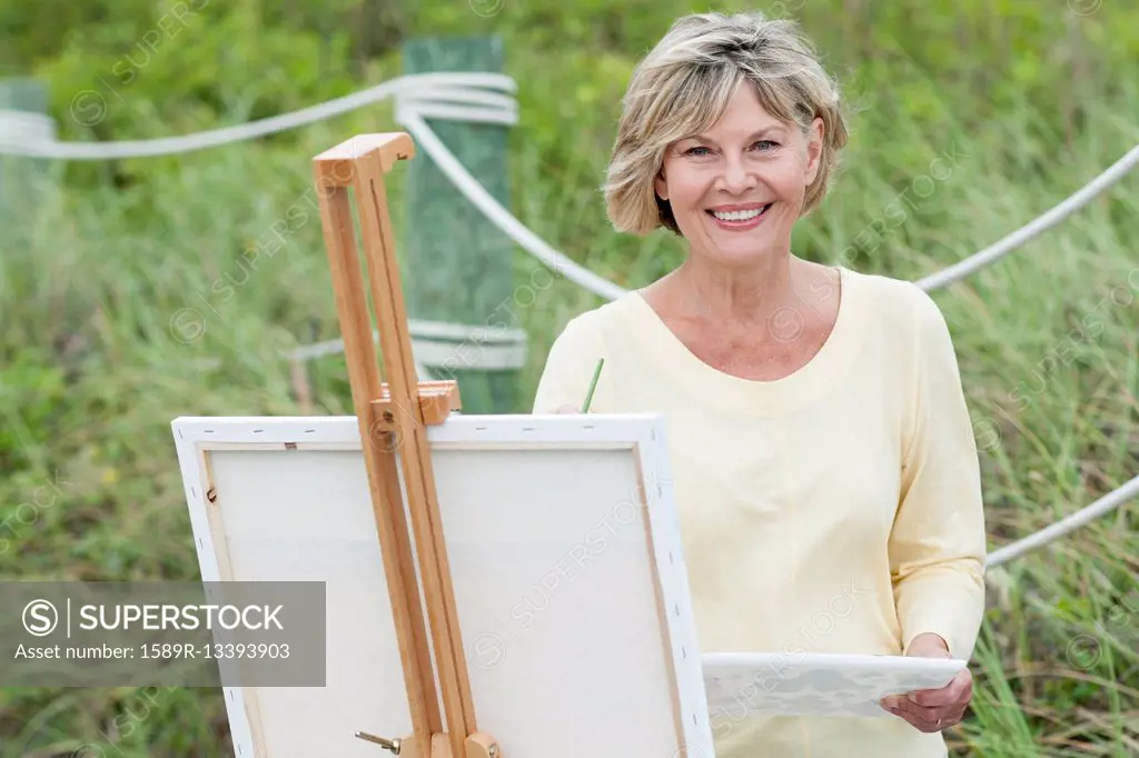 Older Caucasian woman painting outdoors