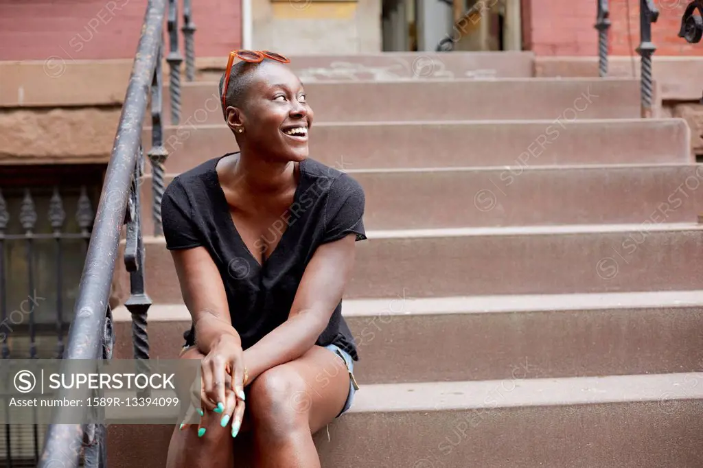 Black woman sitting on urban front stoop