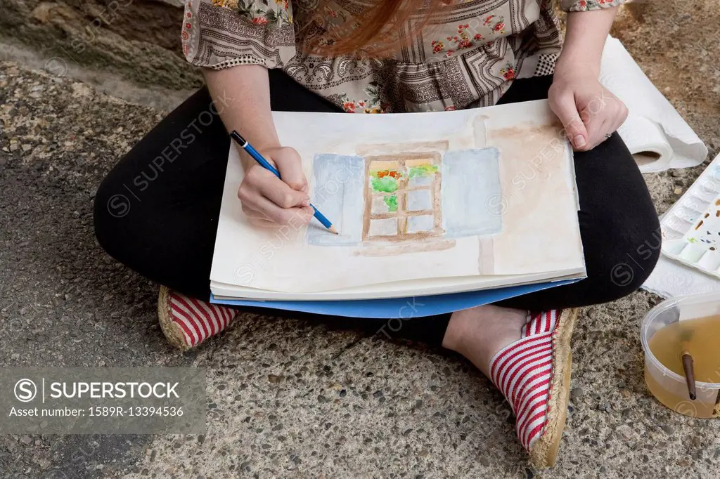Caucasian girl drawing on concrete ground