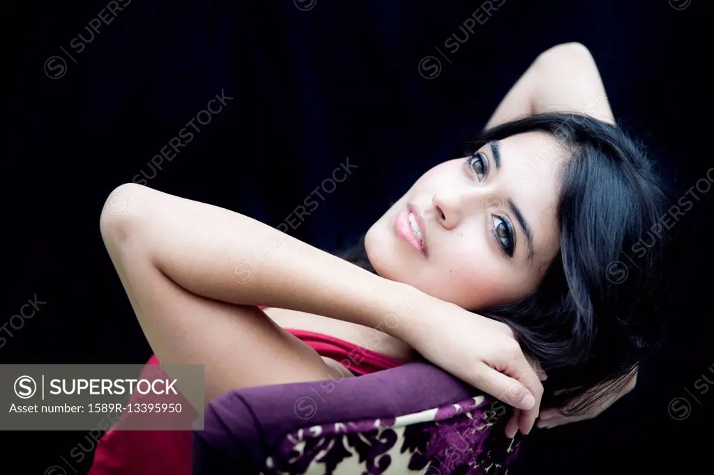 Mixed race woman leaning on armchair