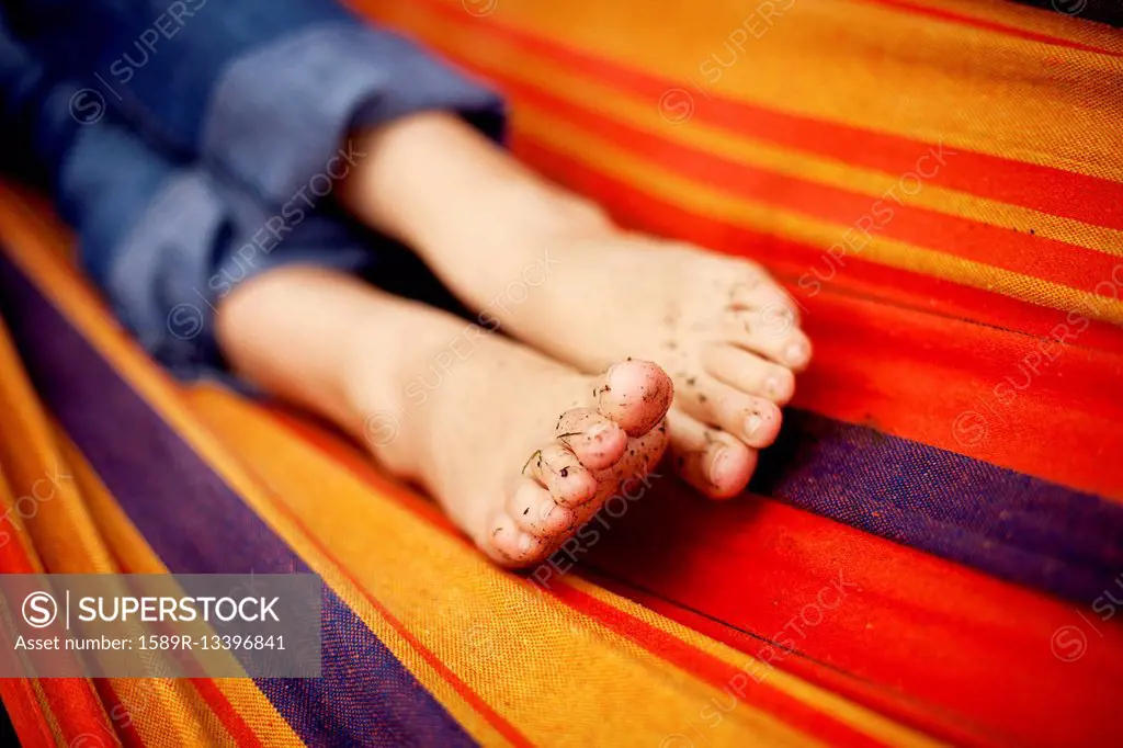 Close up of dirt on feet of girl on hammock