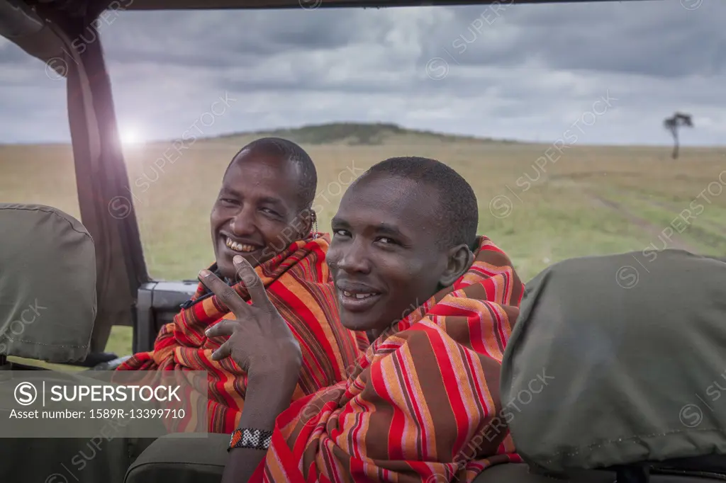 Black men smiling in car in remote field