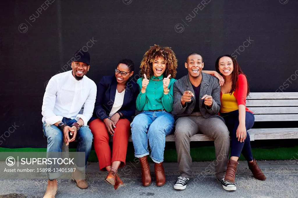 Laughing friends posing on bench