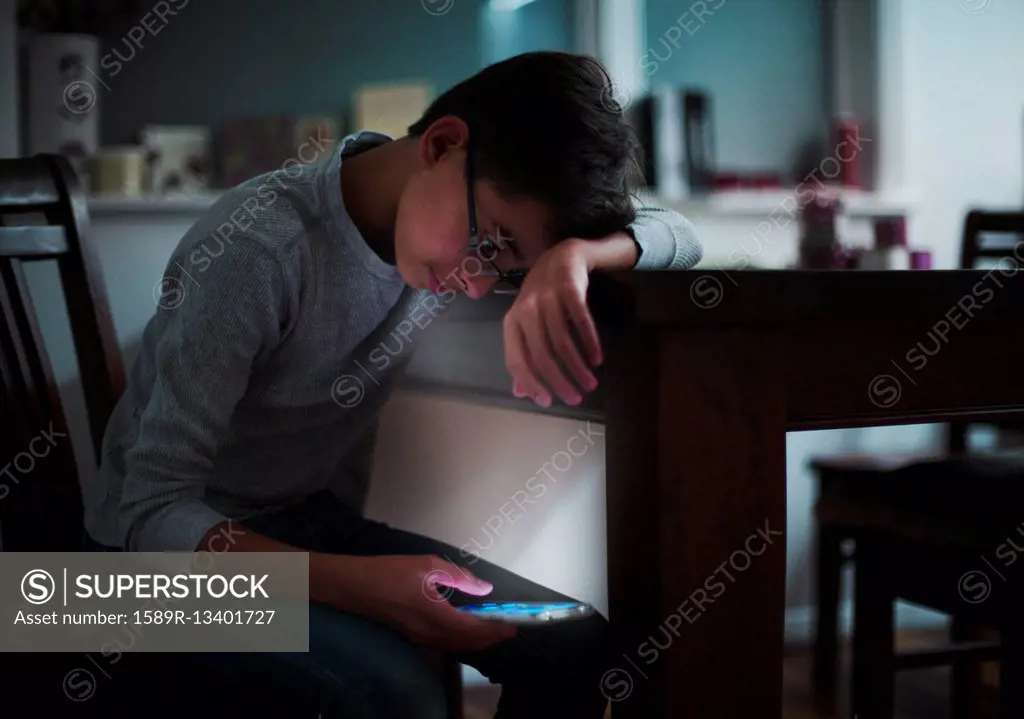 Mixed Race boy using cell phone at night