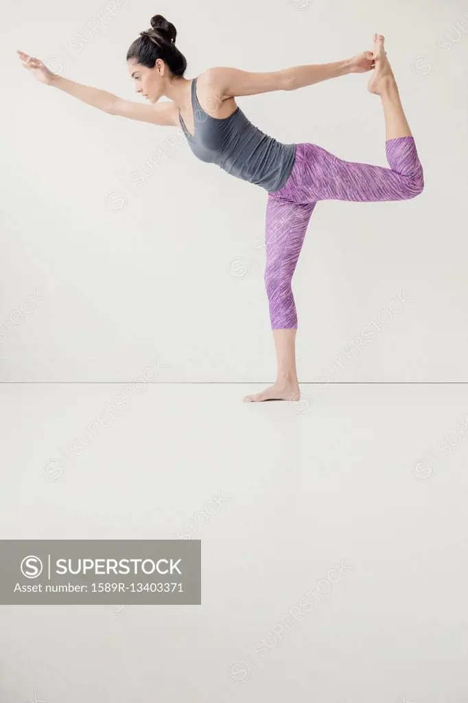 Indian woman holding foot in yoga pose