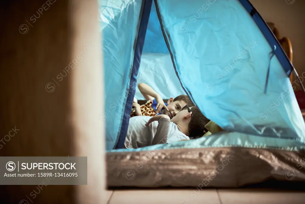Hispanic boys camping in tent indoors