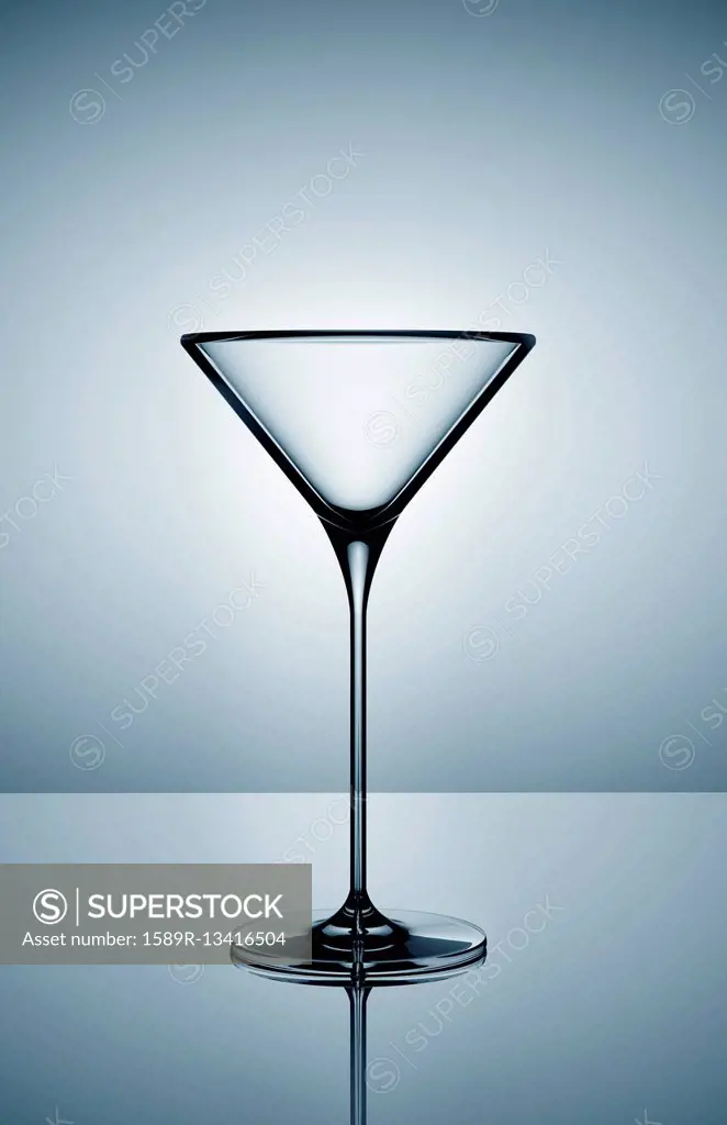 Empty martini glass on gray background