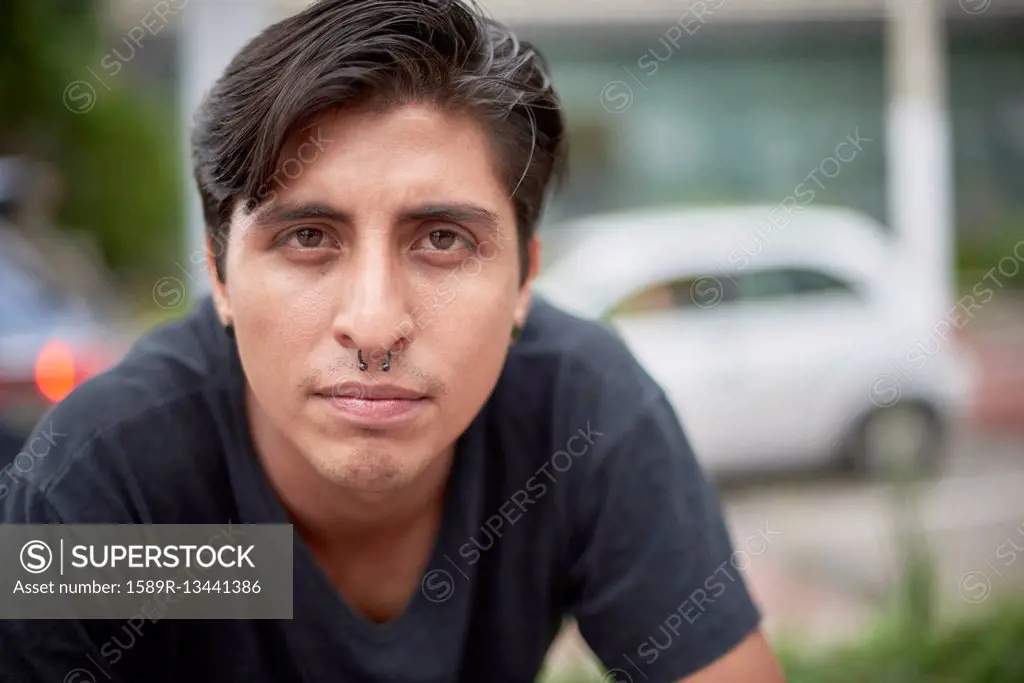 Serious Hispanic man with pierced nose
