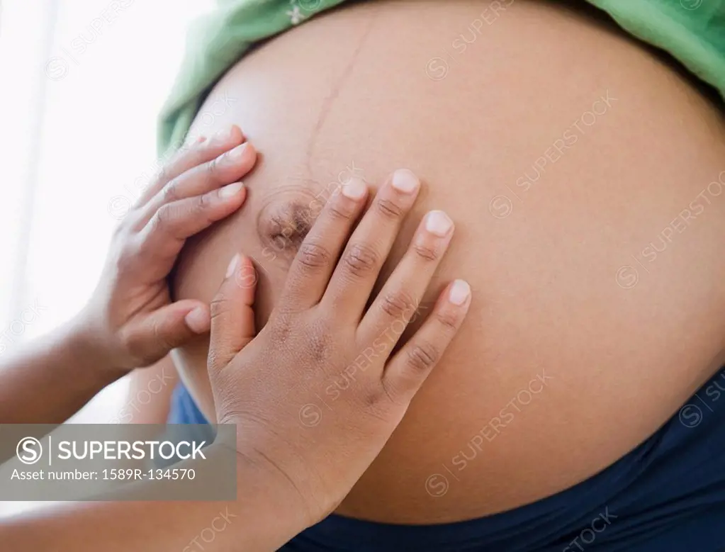 Close up of Black boy touching pregnant mother´s stomach