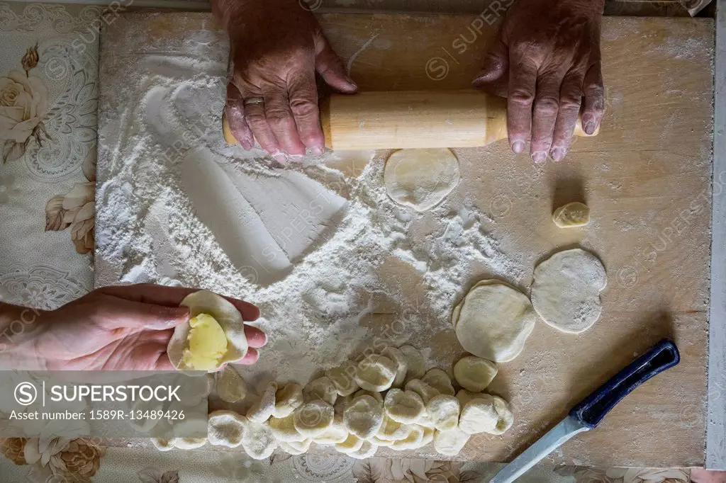 Hands of Caucasian woman rolling pastry dough