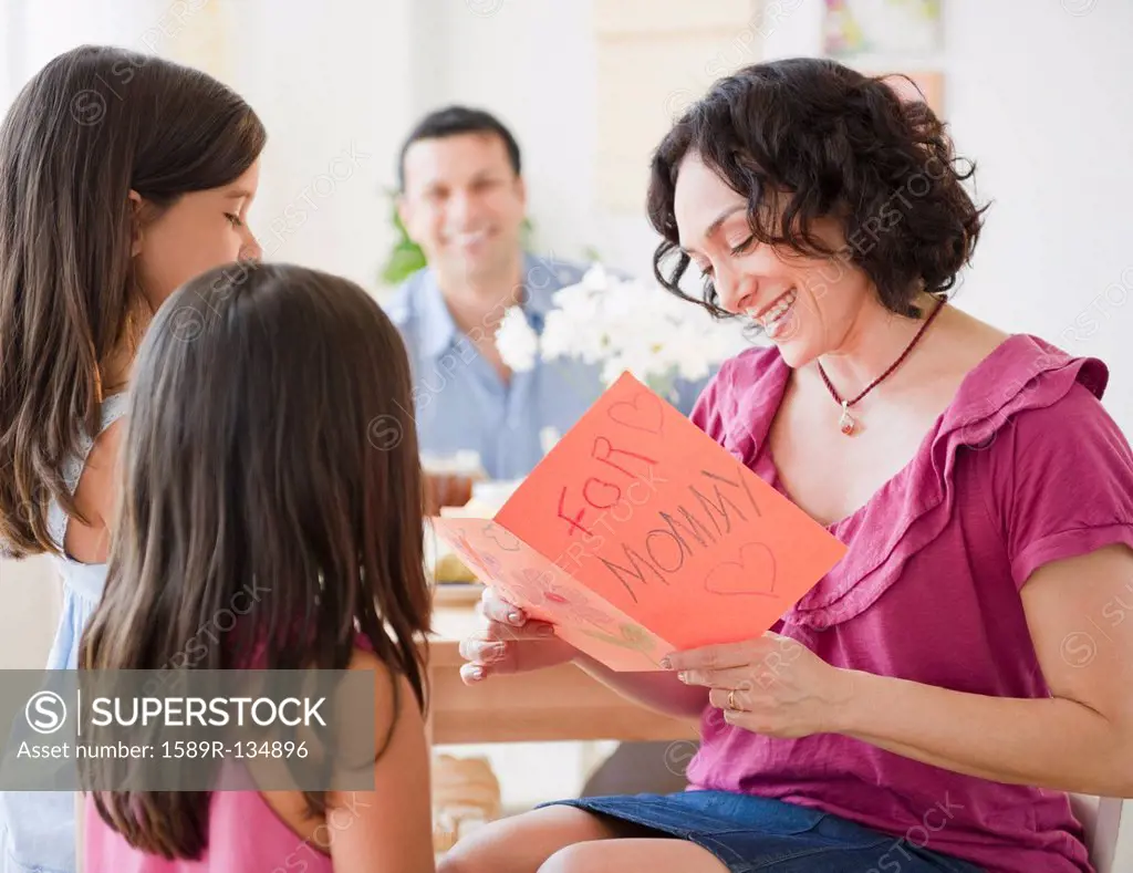 Daughters giving mother Mother´s Day card