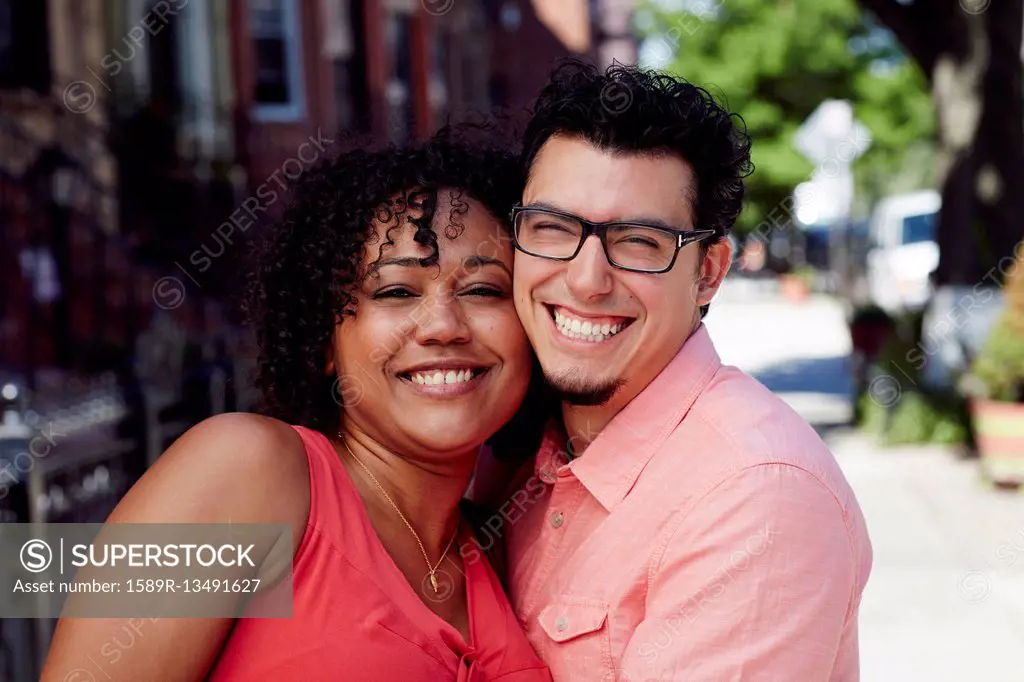 Smiling couple cheek to cheek in city