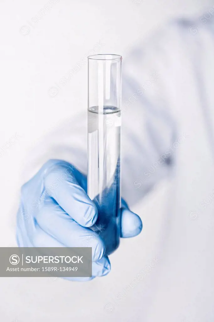 Hispanic scientist holding test tube full of water