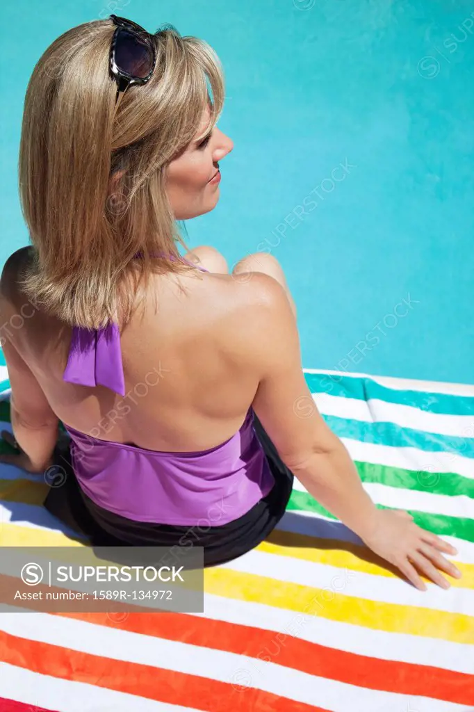 Caucasian woman sitting near swimming pool
