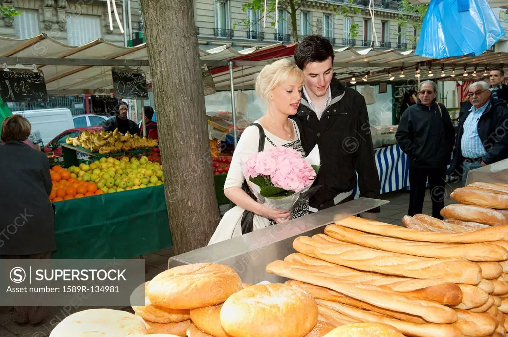 Caucasian couple shopping for bread at market