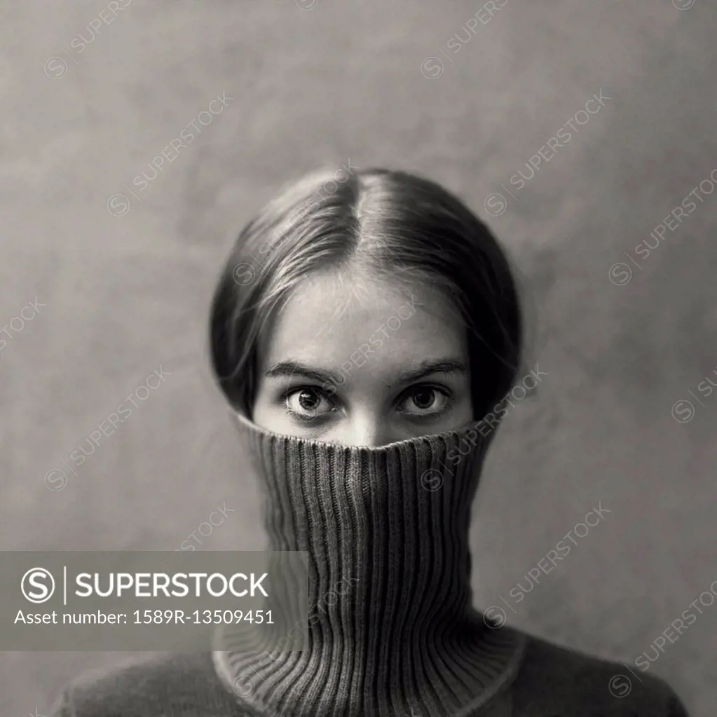 Caucasian girl hiding face in turtleneck