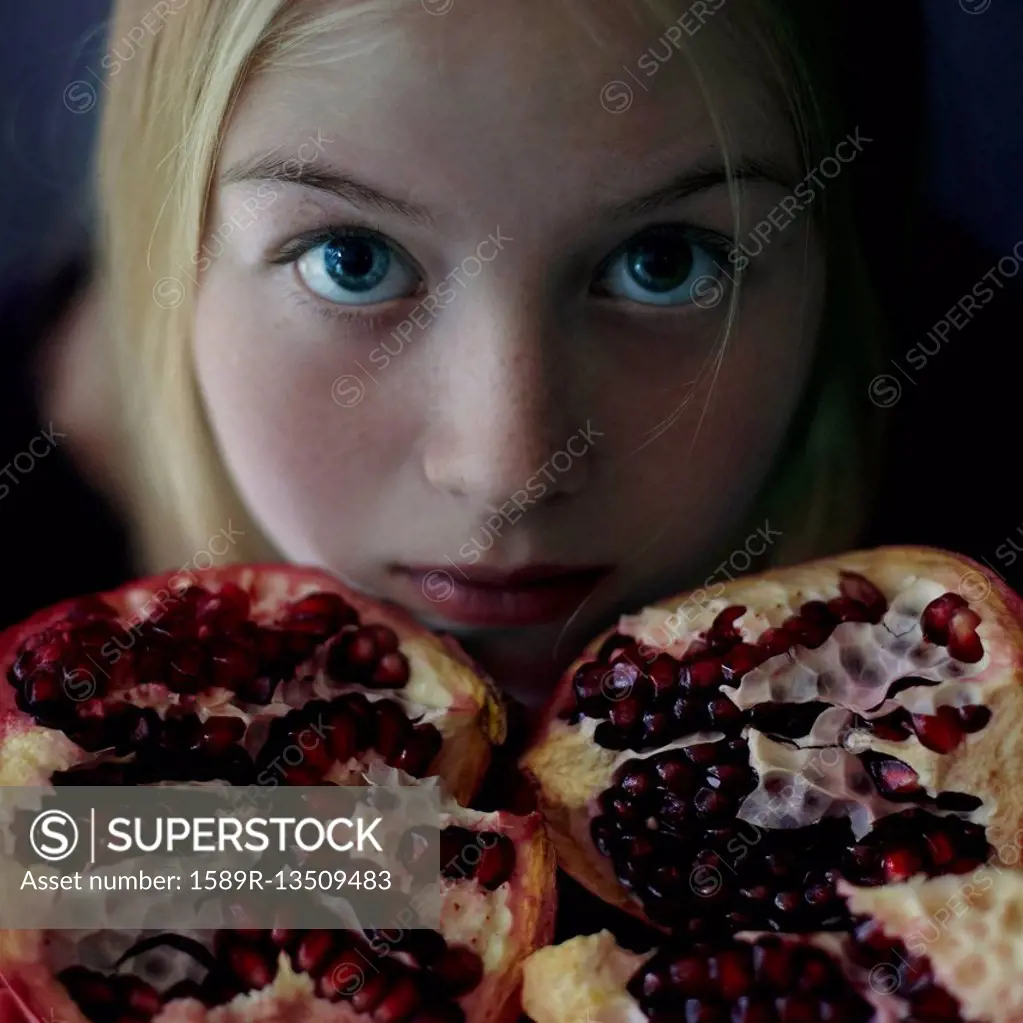 Caucasian girl showing pomegranate slices