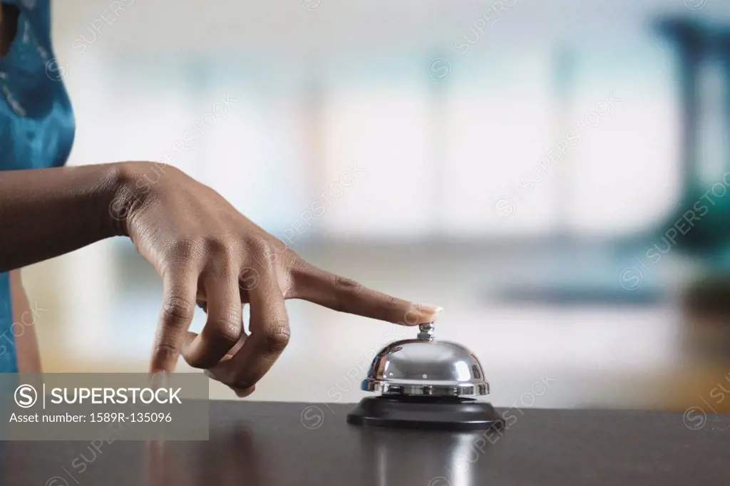Black woman ringing reception desk bell