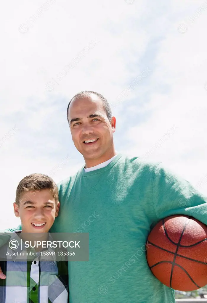 Hispanic father and son with basketball